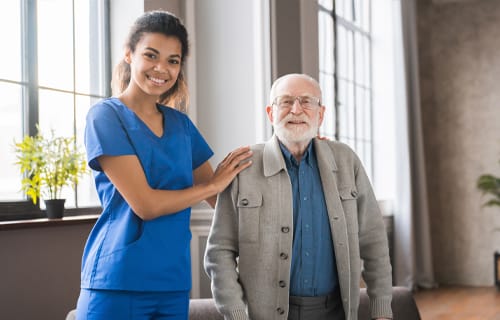 Nurse posing with a resident in a bright interior