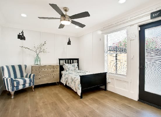 Brightly lit private resident room with furniture