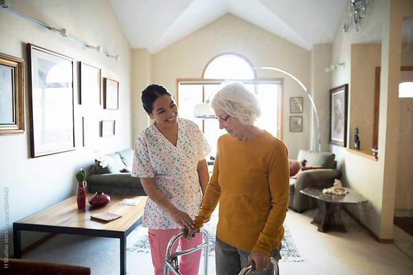 Caregiver assisting a resident in a bright living room