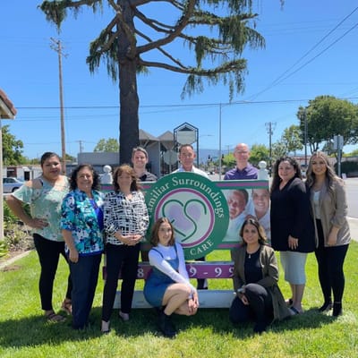 Staff standing in front of the facility sign