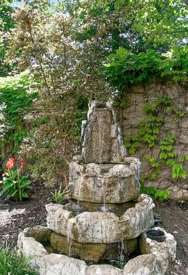 Decorative outdoor fountain surrounded by greenery