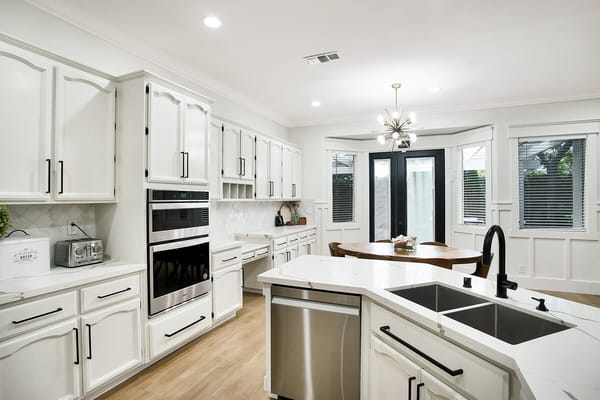 Modern kitchen space with white cabinets and dining table