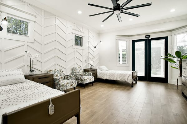 Bright interior room with twin beds and patterned chairs