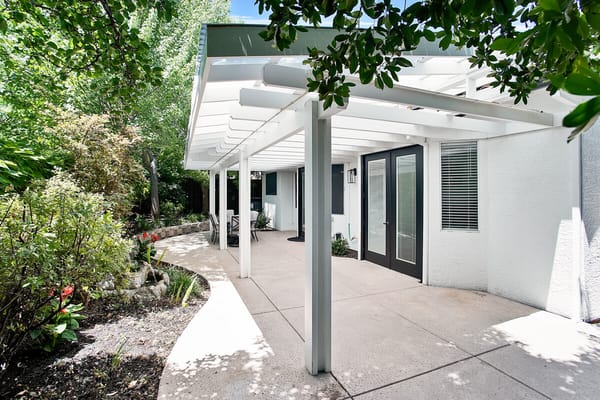 Outdoor patio area with greenery and shaded seating