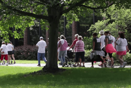 Residents and staff walking in a garden area