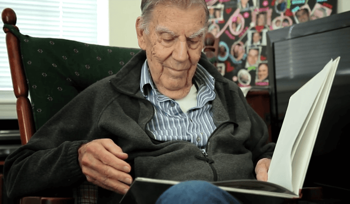 Senior man reading a book in a cozy chair