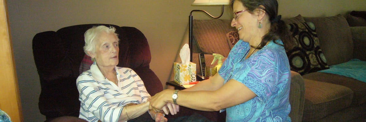 Resident engaging with staff in a cozy interior setting
