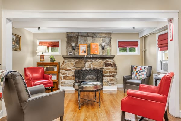 Cozy common area with chairs and a stone fireplace