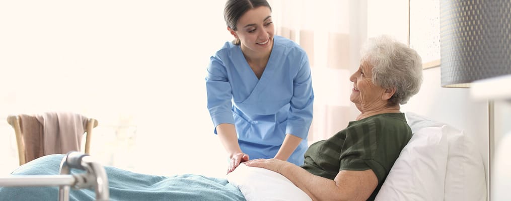 A caregiver assisting a resident in a bright room