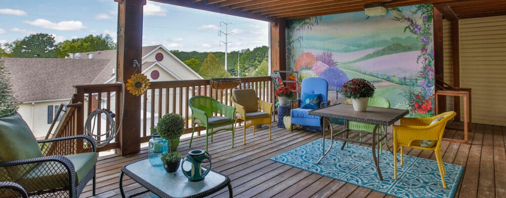 Outdoor seating area with colorful chairs and mural