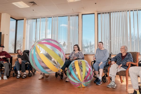 Residents enjoying an activity with colorful beach balls.