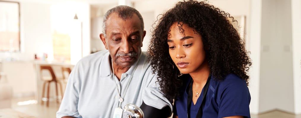 Caregiver taking blood pressure of a senior resident