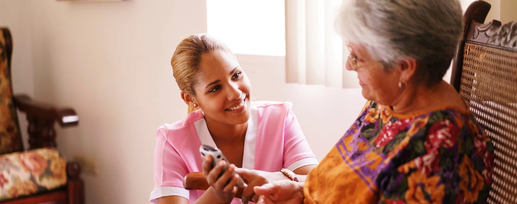 Nurse assisting a senior woman in a caring interaction