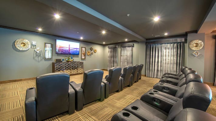 Cozy theater room with reclining seats and a large screen