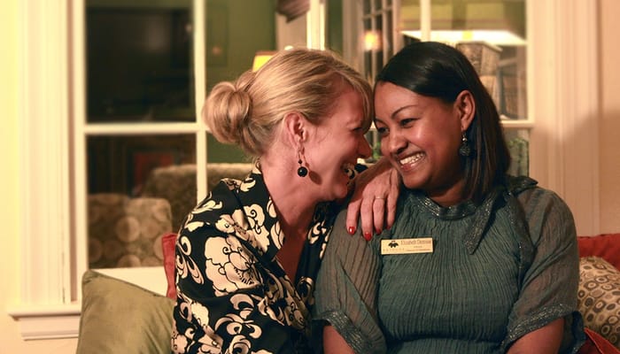 Two staff members sharing a joyful moment indoors