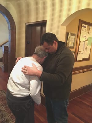 Emotional moment between a resident and staff member in the hallway