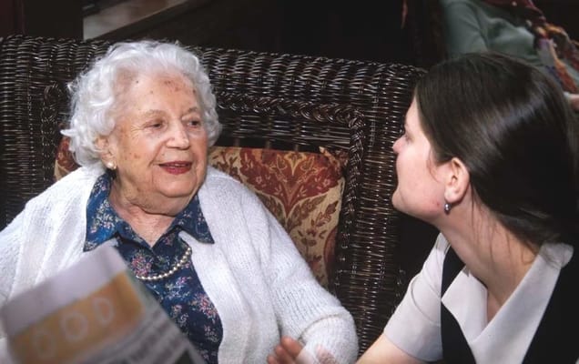 A resident conversing with staff in a comfortable setting