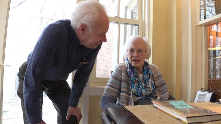 Staff member engaging with a resident in an interior setting