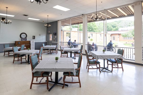 Bright dining area with tables and residents