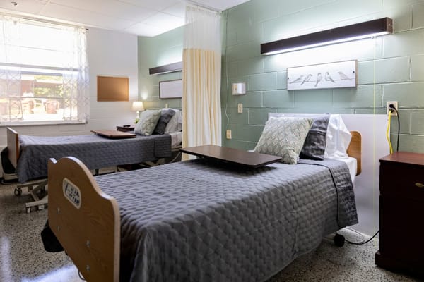 A shared resident room with two beds and decorative elements