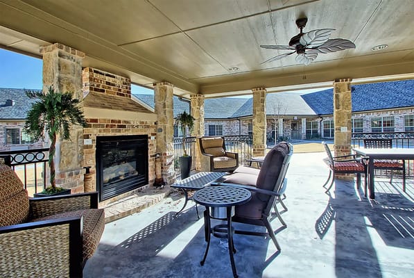 Covered outdoor patio with seating and fireplace