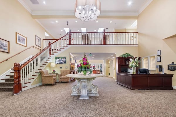 Bright interior of a common area with a staircase and floral arrangement