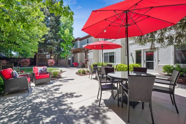Outdoor patio area with red umbrellas and seating
