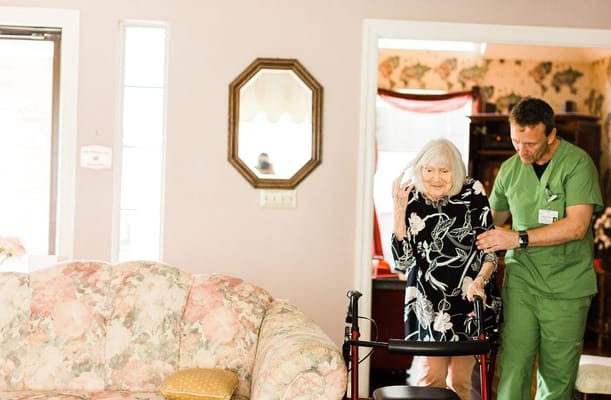 A staff member assisting a senior resident indoors