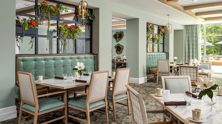 Bright dining area with tables and greenery