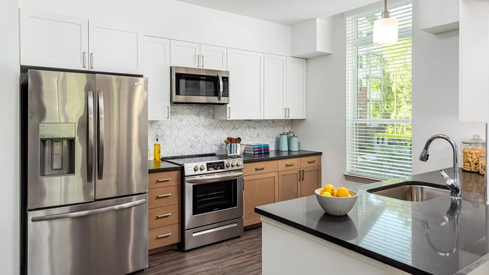 Modern kitchen interior with appliances and a bowl of fruit