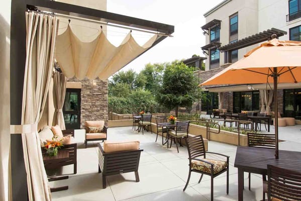 Outdoor seating area with umbrellas and greenery