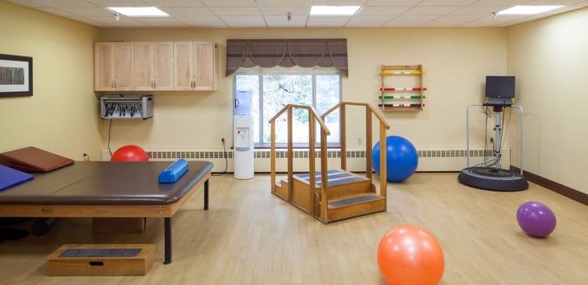 Interior of a therapy room with exercise equipment and colorful balls