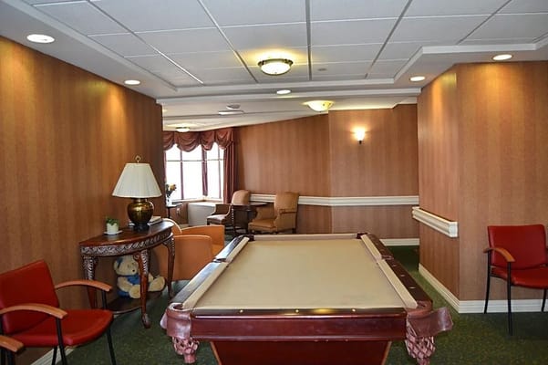 Interior view of the billiards room with a pool table and seating area
