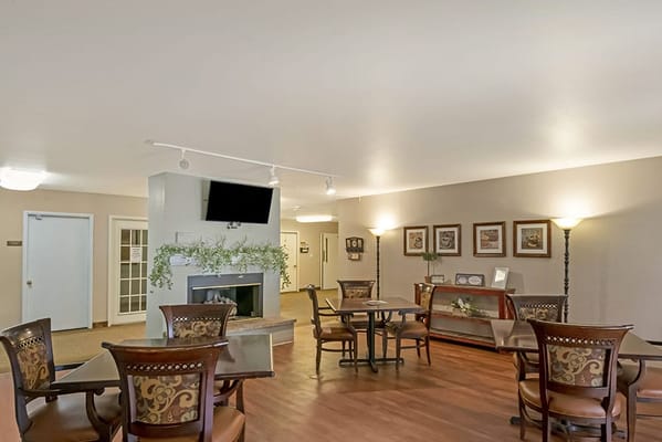 Common area with tables and seating in a senior living facility