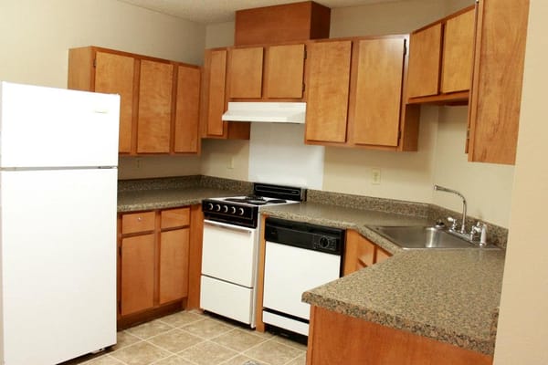 Bright kitchen area with wooden cabinets and appliances