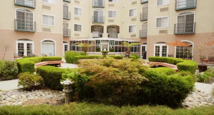 A serene outdoor courtyard with residents relaxing