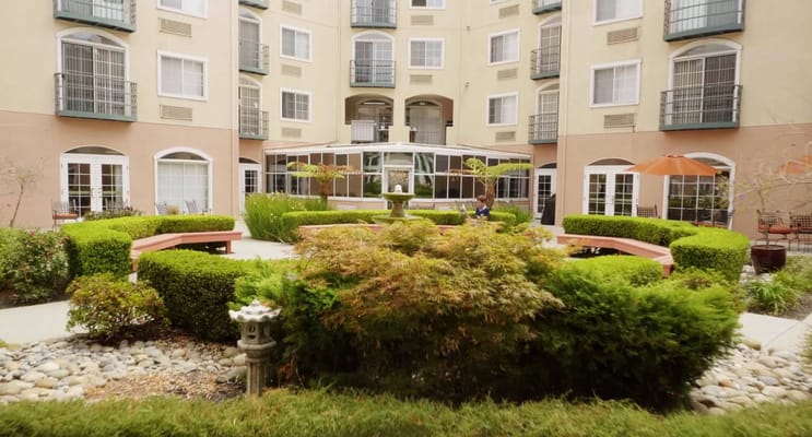 A serene outdoor courtyard with residents relaxing