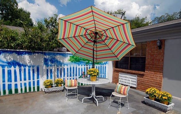 Outdoor seating area with colorful umbrella and flowers
