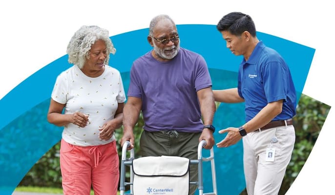 Two seniors with a staff member outdoors