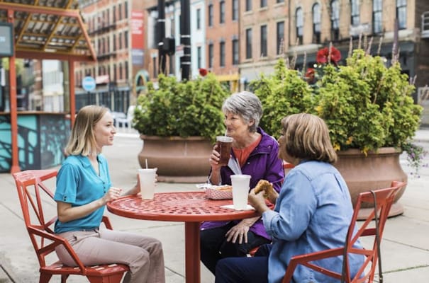 Residents enjoying a meal outdoors at a café table