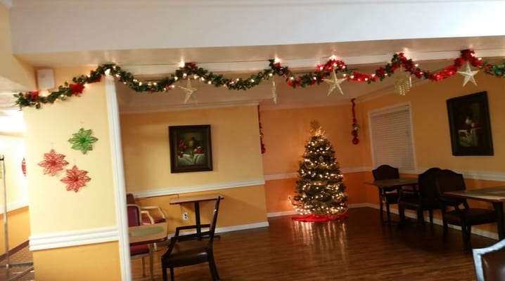 A festive common area decorated for Christmas with a tree and garlands.