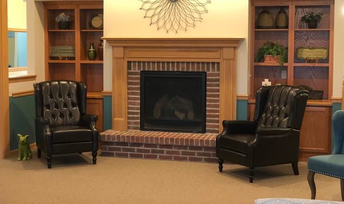 Cozy common area with leather chairs and a fireplace