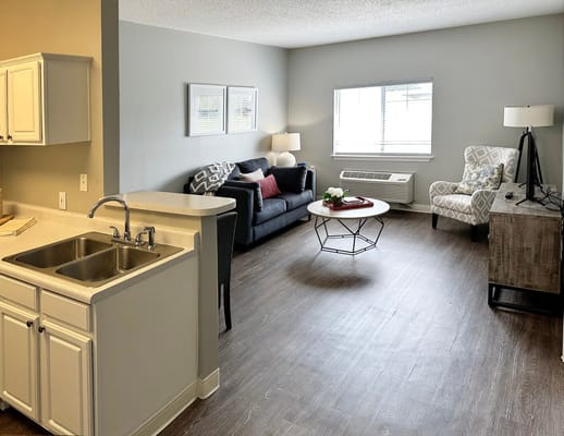 A stylish living room featuring a sofa, armchair, and coffee table.