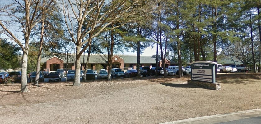 Exterior view of Georgia Home Health facility with trees and parking lot