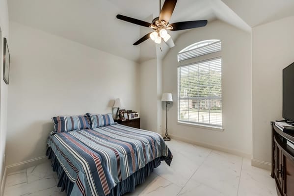 A cozy bedroom with a striped bedspread and natural light.