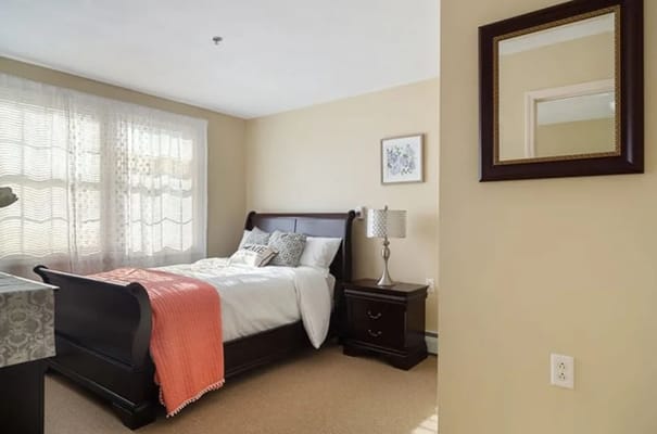 Well-appointed bedroom with a bed, nightstand, and window.