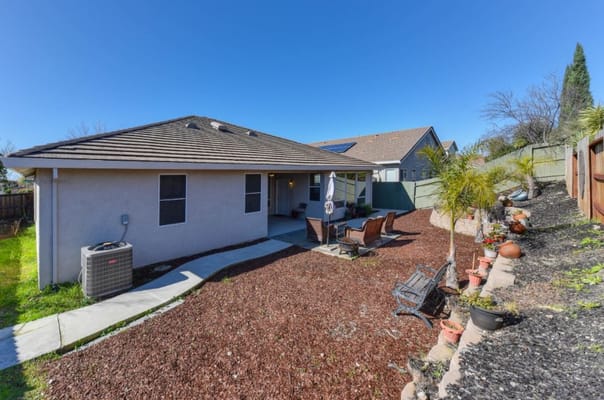 A backyard view with seating area and landscaping