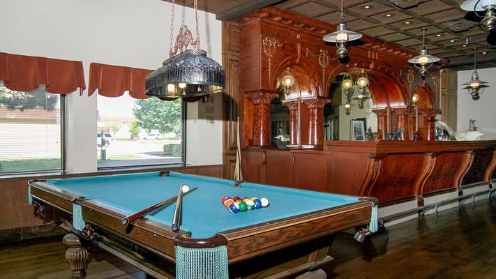 Billiards table in a game room with wooden decor.