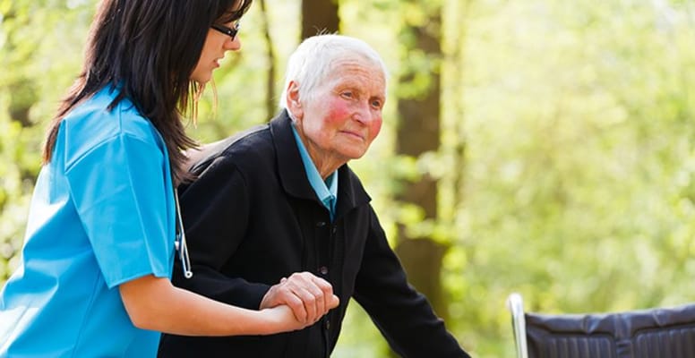 Caregiver assisting an elderly resident outdoors