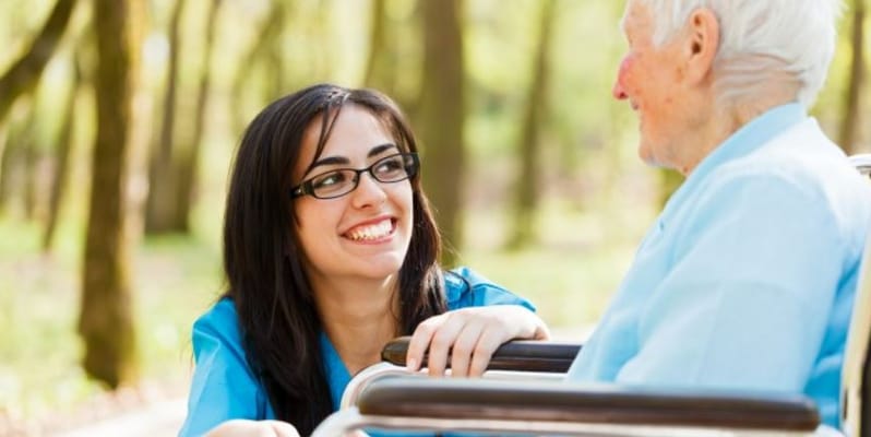 Caregiver interacting with a senior resident outdoors